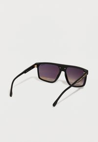 Occhiali da sole neri rettangolari con lenti gradienti viola e sottili dettagli in oro sulle aste, esposti su una superficie bianca.