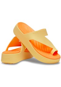 Yellow and orange rubber flip-flops with a wide strap and contoured footbed. Features a cushioned sole and raised texture across.