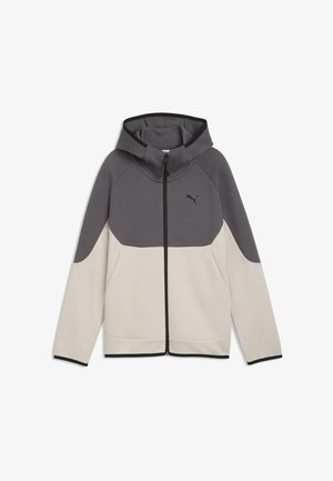 Veste à capuche zippée intégrale avec partie supérieure et manches gris foncé, bas beige clair, poches avant et logo Puma sur la poitrine.