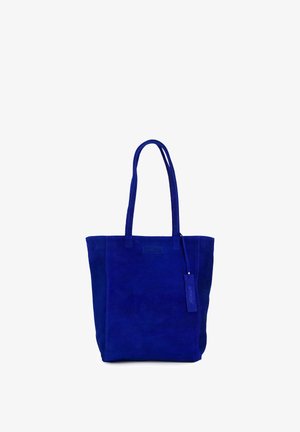 Modrý semišový taška na rameno s dvojitými popruhy a malou zavěšenou visačkou na bílém pozadí.