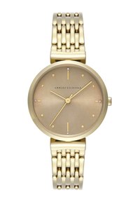 Orologio dorato con quadrante rotondo spazzolato, indicatori delle ore minimalisti e bracciale in metallo con motivo a zigzag. Logo del marchio visibile.