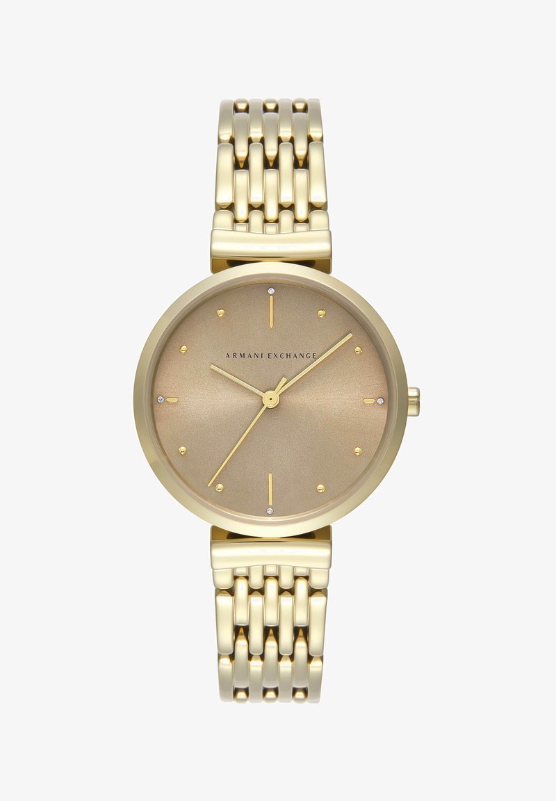 Guldtonet ur med en rund børstet skive, minimalistiske timemarkeringsnumre og et metalarmbånd med et zigzag-mønster. Brandlogo vist.