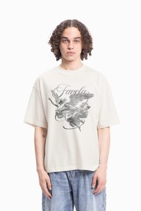 Crème, oversized katoenen T-shirt met een grijze grafische afbeelding van een engel en het woord "Favela" gecentreerd op de voorkant.