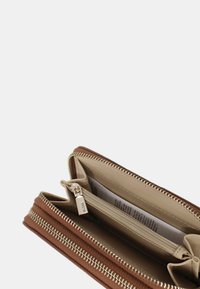 Billetera sintética marrón con una superficie exterior texturizada, compartimentos con doble cremallera y un interior beige. Presenta herrajes en tono plateado y ranuras para tarjetas.