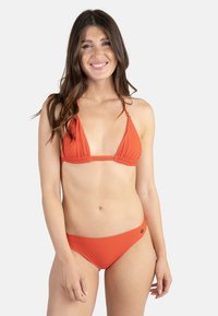 Ensemble bikini orange comprenant un haut triangulaire avec tissu froncé et bretelles ajustables, associé à un bas de bikini taille basse assorti.