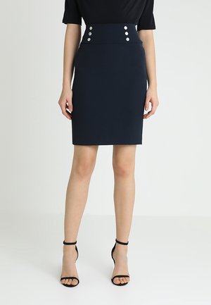 Jupe crayon marine avec taille haute et détails de boutons. Fabriquée en matériau lisse, elle présente une silhouette ajustée et une coupe au genou.