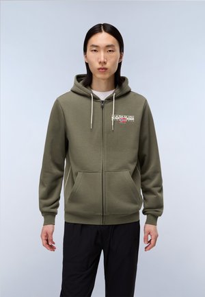 Olive groene zip-up hoodie met zakken aan de voorkant, trekkoorden en gelaagd logo detail op de borst. Gemaakt van zachte stof.