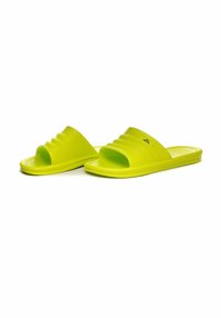 Sandali a scivolo gialli brillanti con una fascia testurizzata caratterizzata da scanalature orizzontali, suola piatta e un design leggero e flessibile.