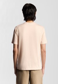 Lichtroze katoenen T-shirt met korte mouwen en een ronde hals, met een gladde textuur en een relaxte pasvorm. Simpel, zonder zichtbare logo's.