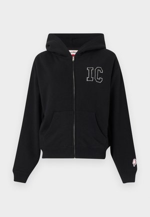 Μαύρο φούτερ με φερμουάρ και μπροστινές τσέπες, λευκά πουά γράμματα "IC" στο στήθος και μικρό ροζ παγωτό σε ύφασμα στο μανίκι αριστερού μανσετώ.