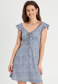 Blue floral dress with short ruffled sleeves, V-neckline, and tie detail at the bust. Features a lightweight fabric and a flared skirt.