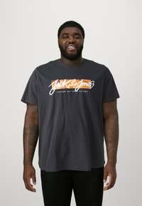 Dark grey cotton t-shirt with short sleeves features a front graphic in white and orange text, reading "Jack & Jones FUTURE OR YOUR FUTURE."