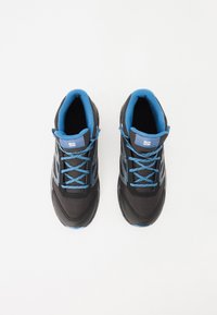 Zapatillas deportivas negras con acentos azules, que cuentan con un upper texturizado, detalles reflectantes y cordones planos. Con un collar y lengua acolchados.