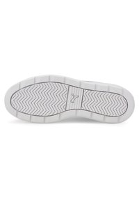 Suela de zapatilla blanca con una superficie de goma texturizada, que presenta un patrón de espiga para tracción y un detalle de logotipo en el centro.