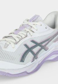 Λευκό και ανοιχτό μωβ παπούτσι τρεξίματος ASICS με επάνω μέρος από δίχτυ, κορδόνια και χαρακτηριστικές διασταυρούμενες λωρίδες στο πλάι.