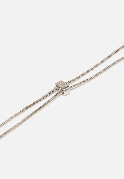 Colier de argint cu două lanțuri subțiri, răsucite, asigurate de un închizător metalic rectangular. Textură netedă și design minimalist.