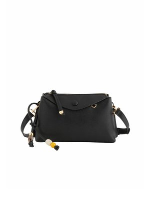 Sac bandoulière noir texturé avec rabat avant, ferrures dorées et pompon décoratif perlé sur la sangle d'épaule réglable.