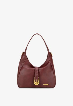 Sac à main en cuir marron foncé avec une seule bandoulière, fermeture à boucle dorée sur le devant, et une petite plaque de marque rectangulaire dorée.