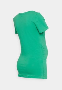 Camiseta de maternidade verde de manga curta com a bainha curved e franzidos laterais para um formato ajustado, feita de tecido suave e elástico.