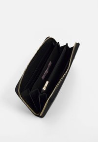 Portefeuille noir avec fermeture éclair, multiple compartiments, quincaillerie dorée et texture lisse. Comprend une poche zippée et une étiquette de marque à l'intérieur.