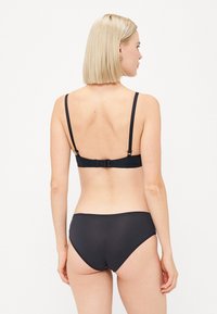 Zwarte bikini-set met een gladde, matte textuur, verstelbare bandjes en een haaksluiting op de rug. Eenvoudig, modern ontwerp.