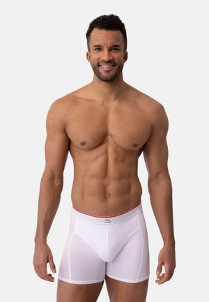 Vita boxershorts med resår i rött i midjan. Tillverkade av ett mjukt tyg med en figursydd design och subtila sömmdetaljer.