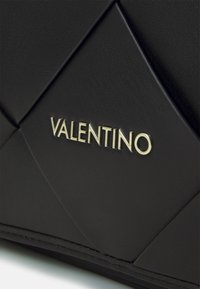 Borsa a tracolla nera in pelle con design trapuntato, logo "VALENTINO" impresso in oro e texture liscia con dettagli di cucitura diagonale.
