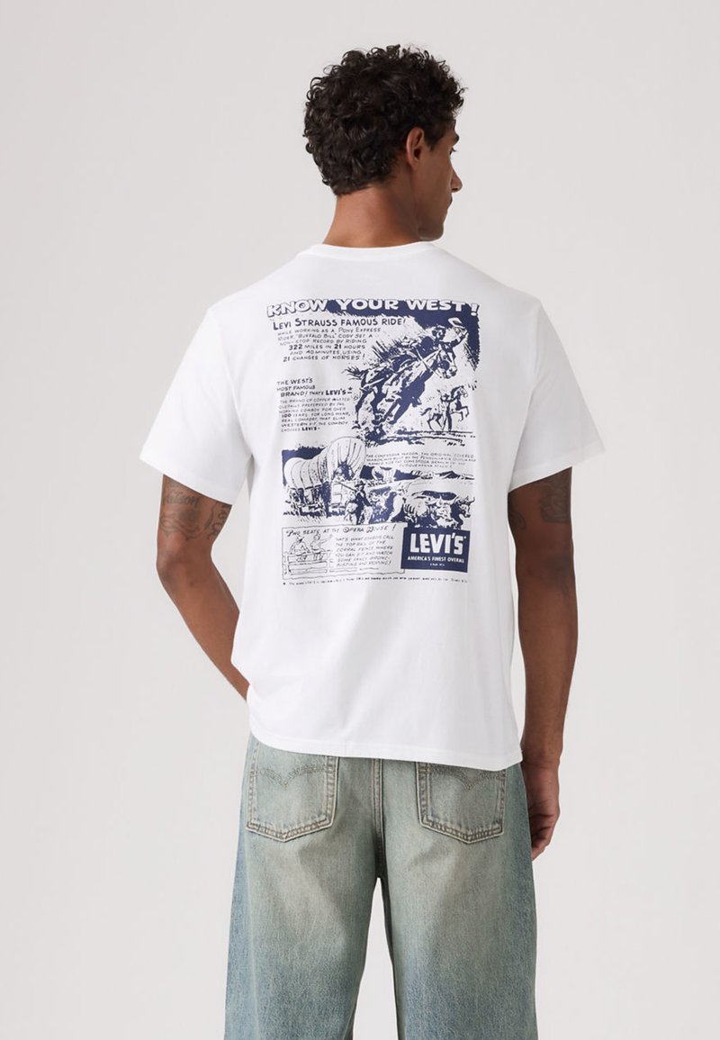 Λευκό βαμβακερό μπλουζάκι με κορυφαίο μπλε γραφικό σχεδιασμό στην πλάτη, που απεικονίζει εικονογραφήσεις και κείμενα με θέμα τη Δύση από τη Levi's.