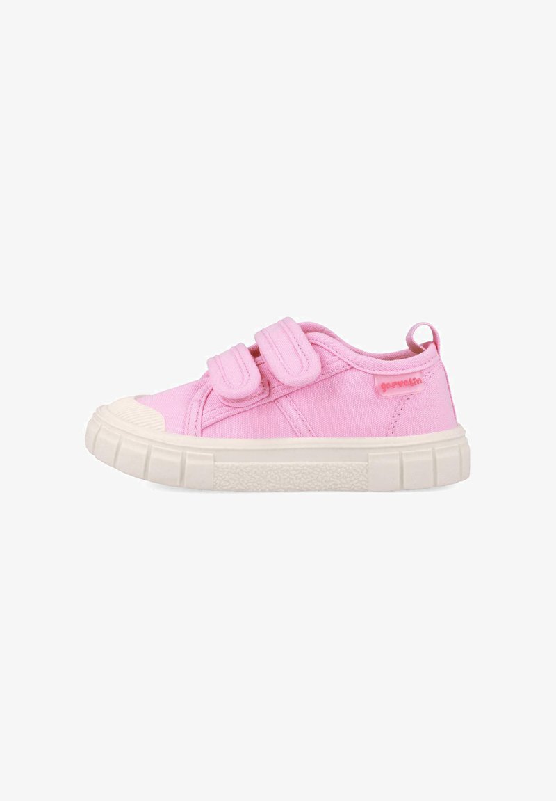 Zapatilla de lona rosa con doble tira de Velcro, puntera de goma y suela blanca texturizada; presenta un pequeño logo en el costado.
