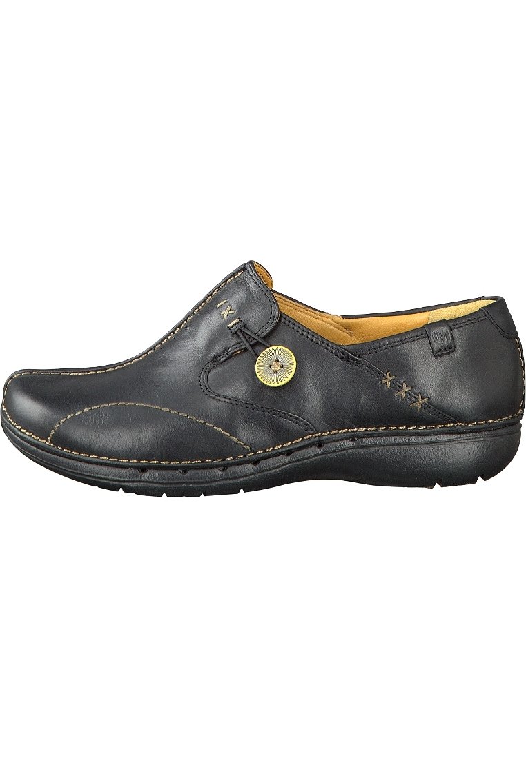 Schwarzer Lederschuh mit dekorativen Nähten, einer runden Spitze und einem runden Knopfakzent. Das Innere hat ein weiches, gelbes Futter.