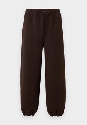 Σκούρο καφέ φόρμα με ελαστική μέση και κορδόνι, με ελαστικές μανσέτες στους αστραγάλους, εμφανίζεται σε απλό ανοιχτό φόντο.