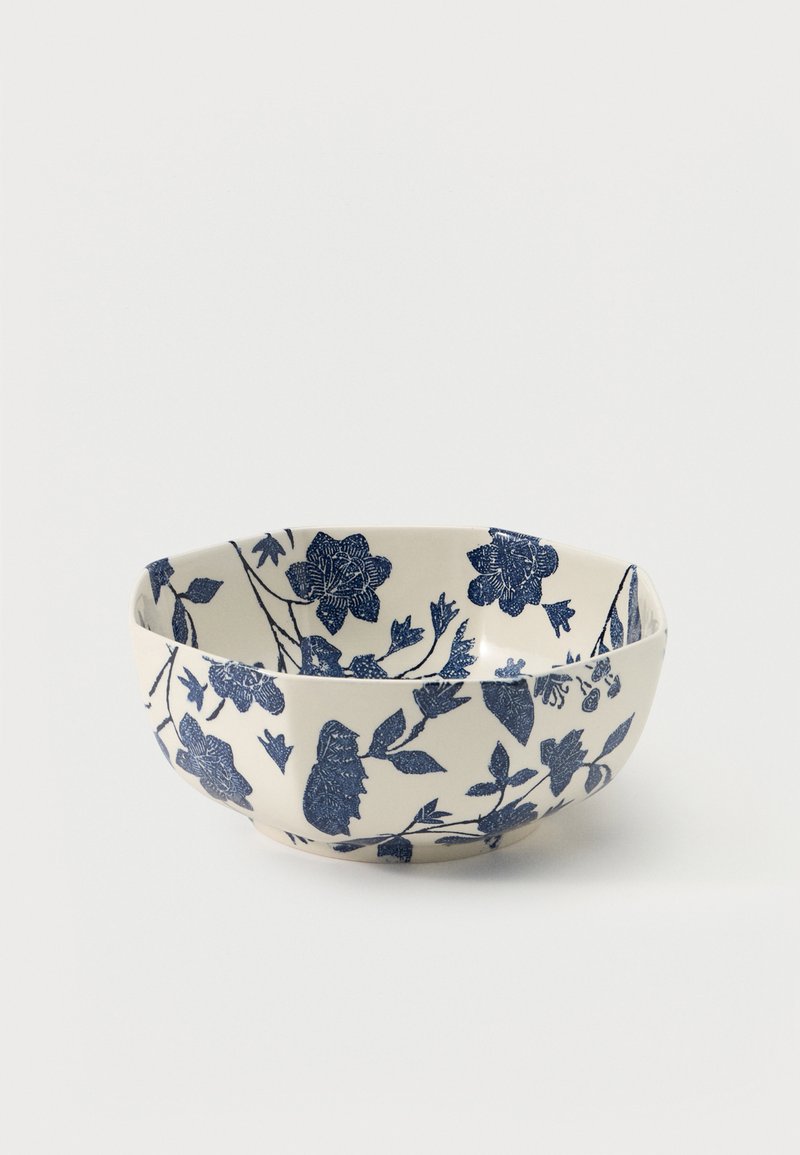 Keramisk bolle med avrundede kanter, dekorert med mørkeblå blomster på hvit bakgrunn.