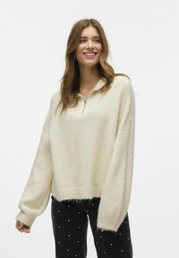 Svijetlo bež, preveliki fleece pulover s polu-zip ovratnikom i dugim rukavima, s mekanom teksturom i rebrastim donjim rubom.