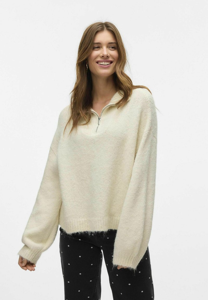 Svijetlo bež, preveliki fleece pulover s polu-zip ovratnikom i dugim rukavima, s mekanom teksturom i rebrastim donjim rubom.