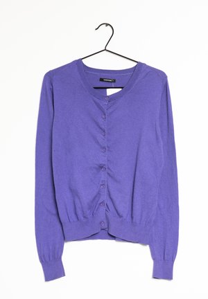 Gilet violet à manches longues, col rond et boutons sur le devant, suspendu à un cintre noir sur fond blanc uni.