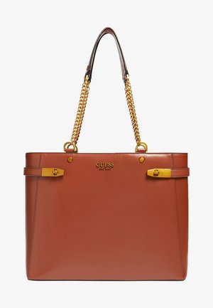 Sac fourre-tout Guess en cuir marron avec poignées en chaîne dorée, accents de boucle dorée sur les côtés et logo embossé au centre à l'avant.