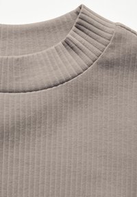 Licht taupe ribbelstof met een hoge, brede halslijn. De textuur is zacht en licht elastisch, met verticale lijnen door de stof heen.