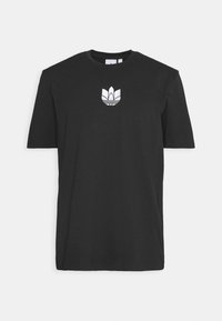 Svart t-shirt med kort ärm i bomull. Har en vit broderad logotyp på bröstet och rund halsringning. Enkel, klassisk design.