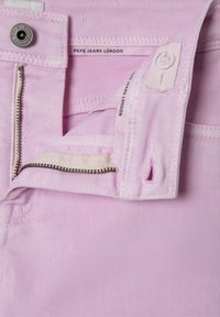 Svetloružové džínsy so zipsom, zapínaním na gombík a vnútorným etikettou so značkou "Pepe Jeans London." Textúrovaná tkanina s diagonálnymi pruhmi.