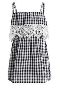 Schwarz-weißes karriertes ärmelloses Kleid mit dünnen Trägern und weißer Spitzeneinfassung über der Brust.