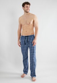 Heren pyjamabroeken in een blauw geruit patroon, met een trekband in de taille, een losse pasvorm en lichtgewicht stof. Soepele textuur.