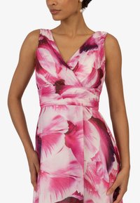 Blumenkleid mit V-Ausschnitt, rosafarbenen und lila Blumenmustern, gerafftem Taillendetail und leichtem, fließendem Stoff.