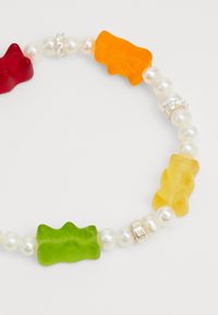 Bunte, gummibärchenförmige Perlen in Rot, Grün, Gelb und Orange sind mit runden weißen Perlen und silberfarbenen Abstandshalterperlen durchmischt.