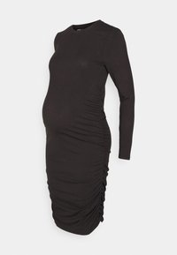 Robe de maternité à manches longues, couleur marron foncé, avec une texture côtelée, dotée de détails froncés sur le côté pour une silhouette ajustée et extensible.