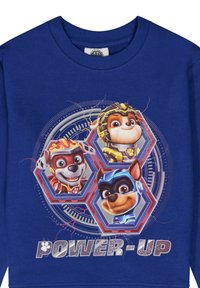 Camiseta de algodón azul de manga larga con tres perros de dibujos animados en medallas hexagonales y el texto "POWER-UP" en una fuente negrita y texturizada.