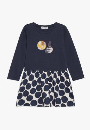 Navy sininen pitkähihaisen mekko, jossa on pilkullinen hame. Mekossa on brodeerattu kuvio, jossa on ympyröitä ja lehti keltaisilla, valkoisilla ja punaisilla yksityiskohdilla.