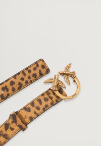 Leopárdmintás velúr öv aranyszínű gyűrűcsattal, amelyen két madár díszítés található. Az öv pántja sima felületű és varrott szélekkel rendelkezik.