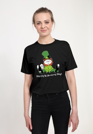 Schwarzes T-Shirt mit einer Cartoon-Illustration eines Leprechauns, der einen grünen Hut und einen orangefarbenen Bart trägt. Der Text lautet: "Frohen St. Trinktag!" in Weiß.