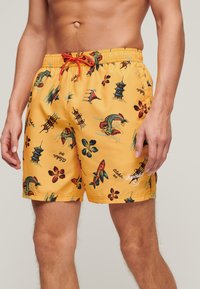Pantaloni da bagno gialli con grafiche colorate ispirate all'Asia, tra cui pesci e fiori, con vita elastica e stringa.