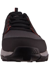 Black athletic shoe with mesh upper, reinforced toe, orange accents, and rugged sole for traction. Features supportive lacing system.